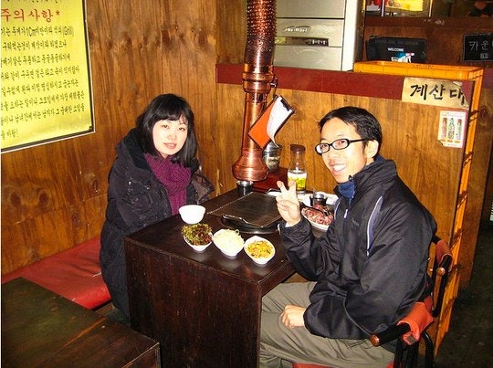 A Korean couple at a table with a gogigui. By Wootang01 (Flickr)