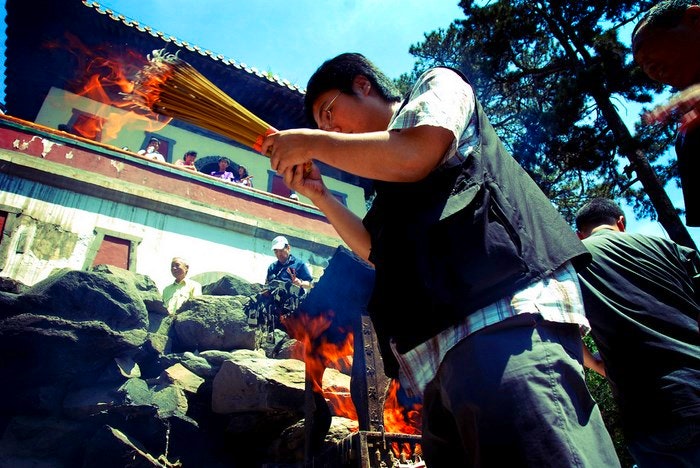 Incense offering and a prayer. By Edwin Lee (Flickr)