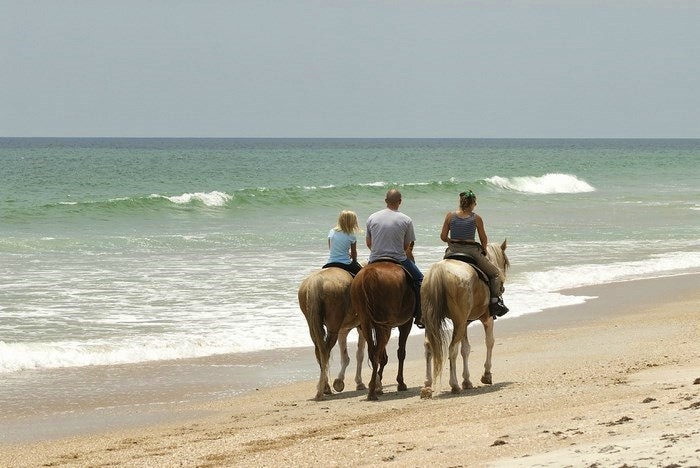 Horse back riding on the beach. By grandvelasrivieramaya (Flickr)