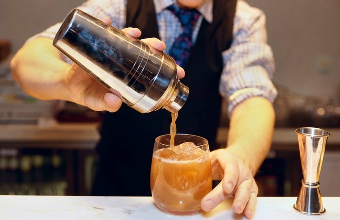 Bartender pouring a cocktail via BigStock