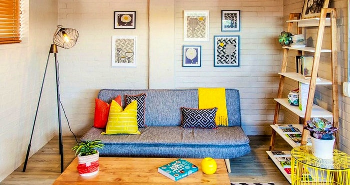 The bold scatter cushions and bright pops of colour give a wonderful element of quirkiness to this apartment | Photo: TravelGround